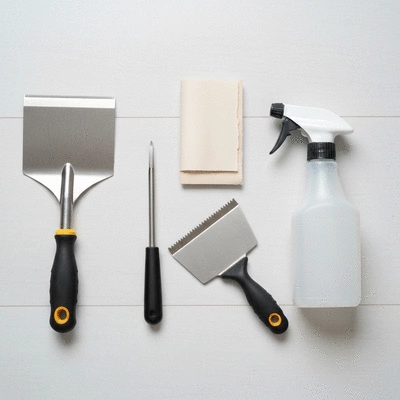 Variety of wallpaper removal tools on a clean surface